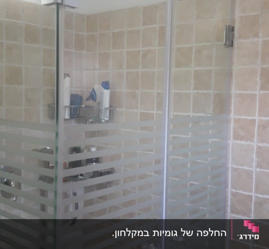 מקלחון זכוכית פינתי עם עיטור פסים וצירי מתכת